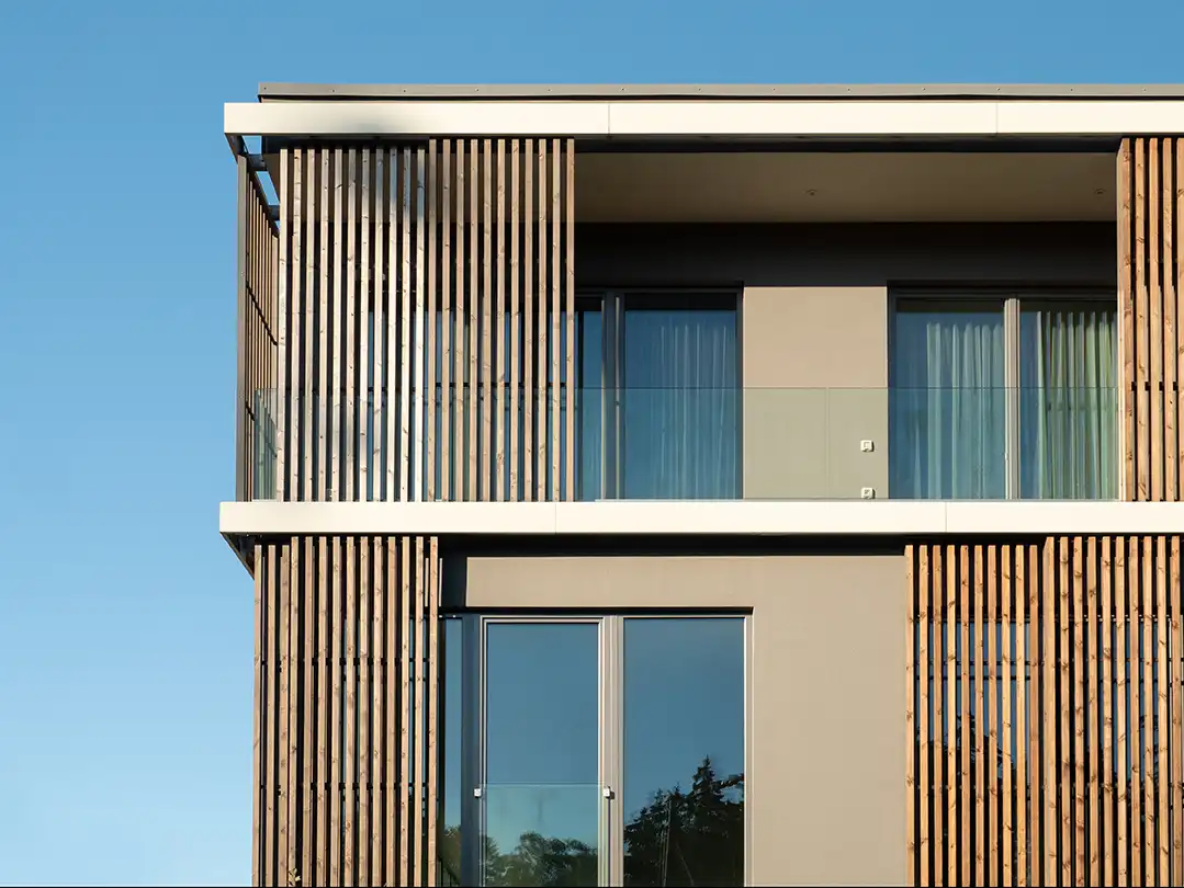 Modernes Gebäude mit vertikalen Holzlamellen an der Fassade und Balkon