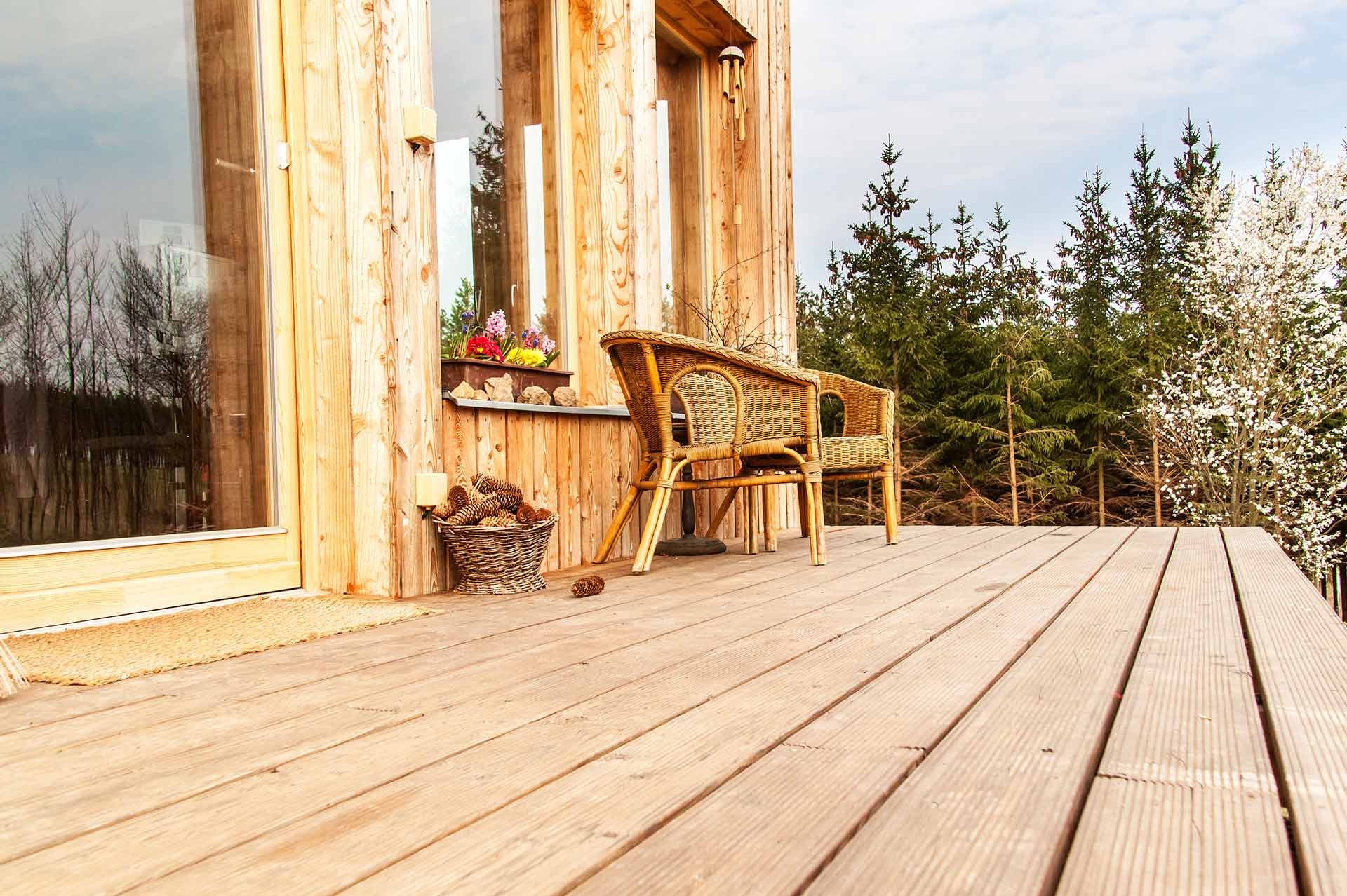 helle Terrassendielen aus Holz vor Haus mit ebenfalls heller Holzfassade